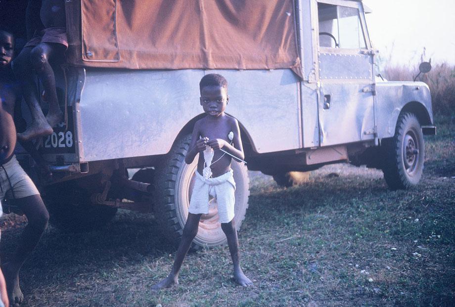 I have no information on this young man, but the picture holds so much interest for me, and for my mother Im sure. With the safari style Land Rover in the background (note the painted on license plate!) and the obvious roughness of the environment, the delicate knitting work in his hands makes quite a contrast.