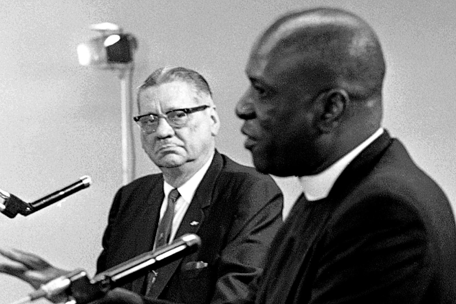 A black-and-white photo featuring Walter Headley and Theodore Gibson seated in front of microphones.