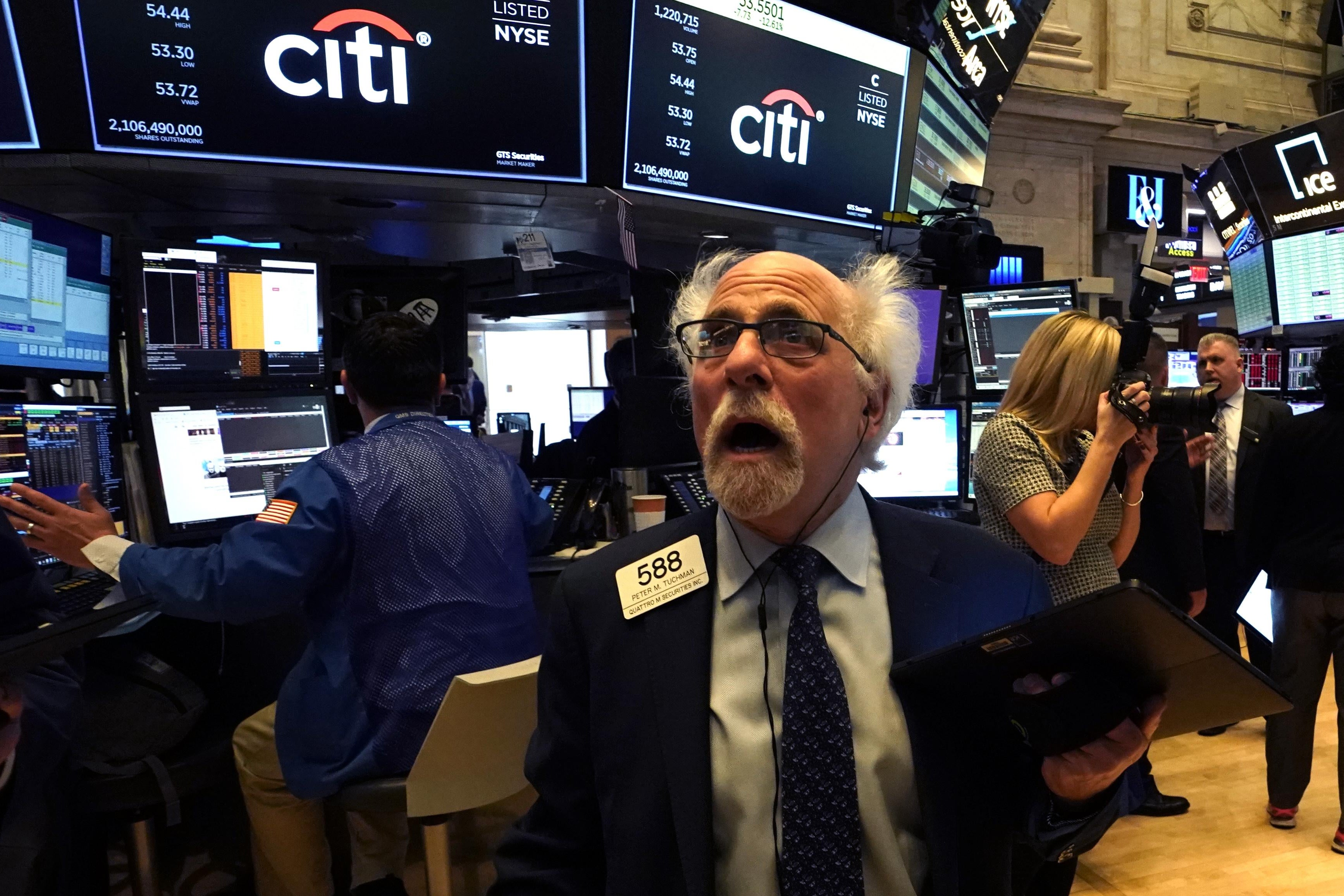 Peter Tuchman, floor trader, reacts as he works on the floor during the opening bell on the New York Stock Exchange on March 9, 2020 in New York. He has a bald head and side hair puffs and his mouth is wide open. He is freaking out.