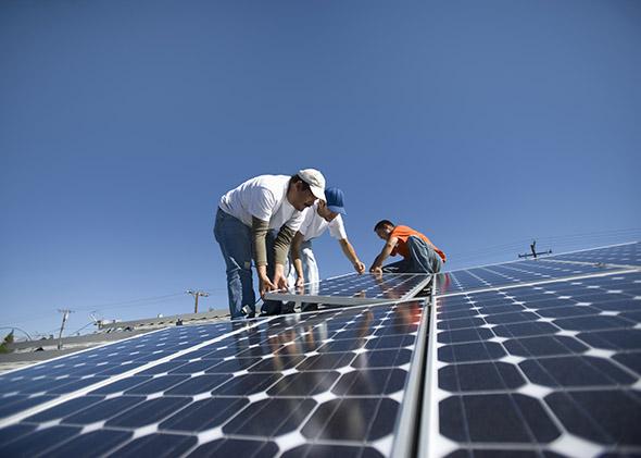 A group of men working on solar panelling.