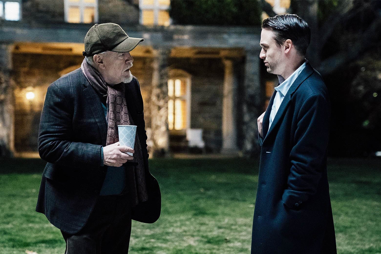 Brian Cox and Kieran Culkin stand on a lawn outside a big house in a still from Succession.