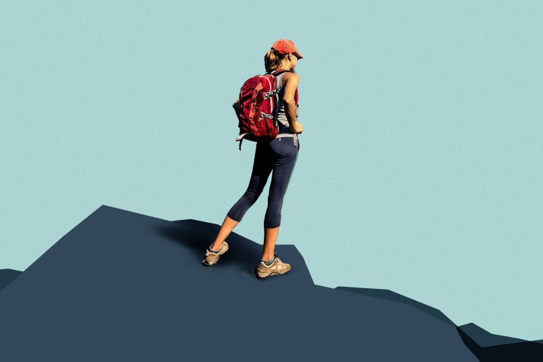 A woman in hi-tech hiking gear on the top of a mountain.