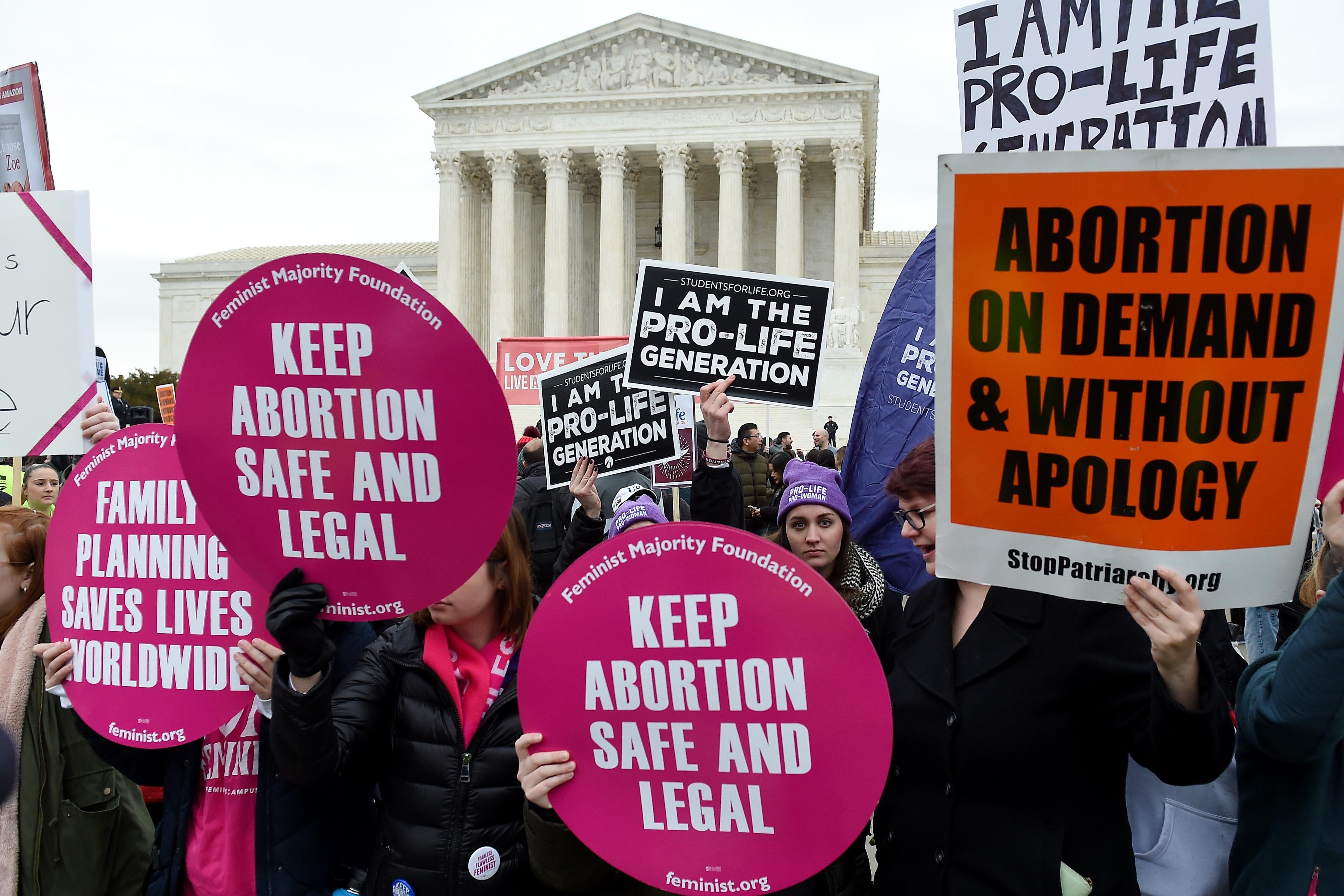 A crowd of protesters holding signs for and against abortion outside the Supreme Court