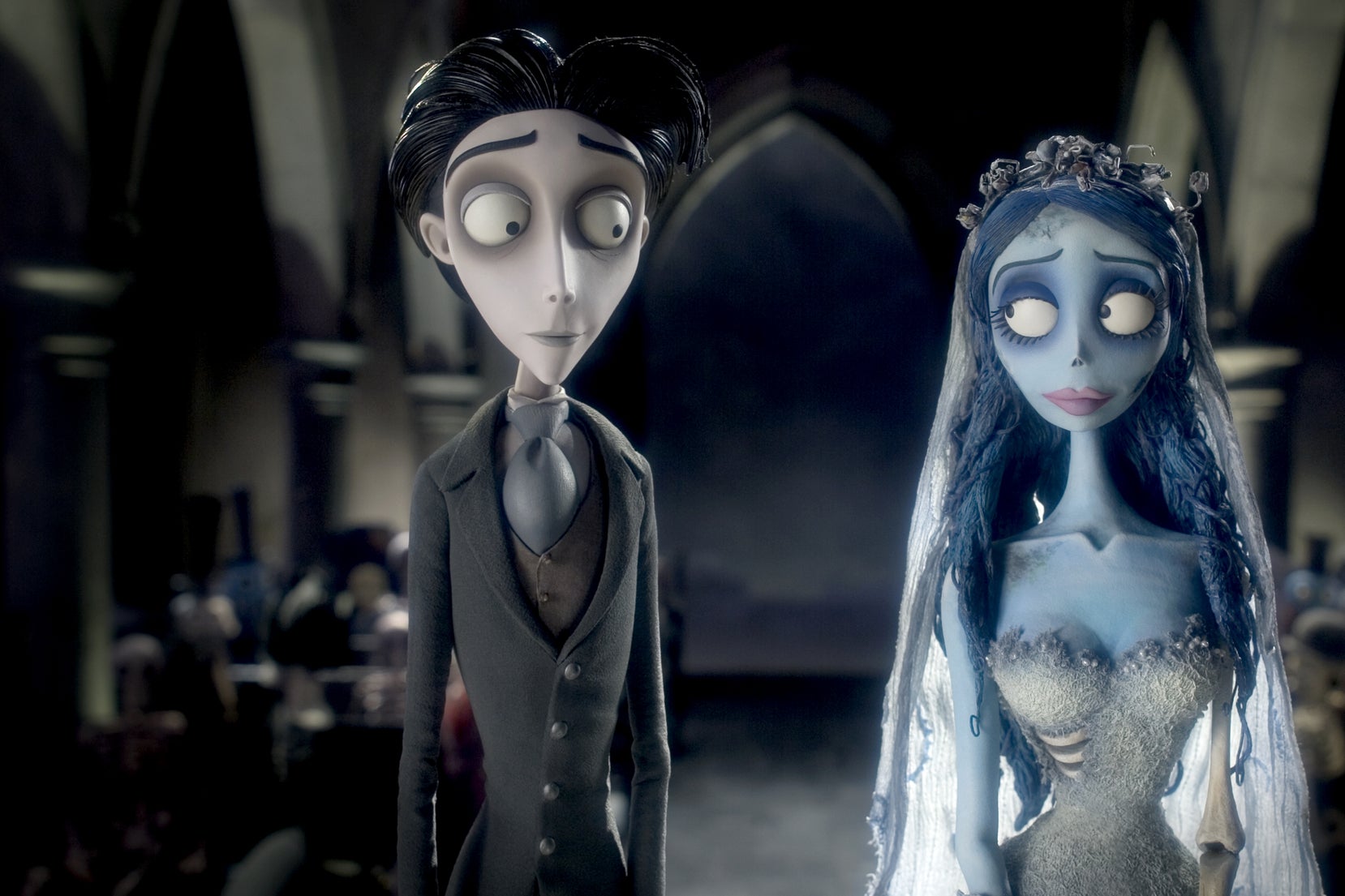 An animated skinny pale man with dark hair and hollow dark-circled eyes stands at the altar with an animated female blue-skinned corpse in a wedding dress.