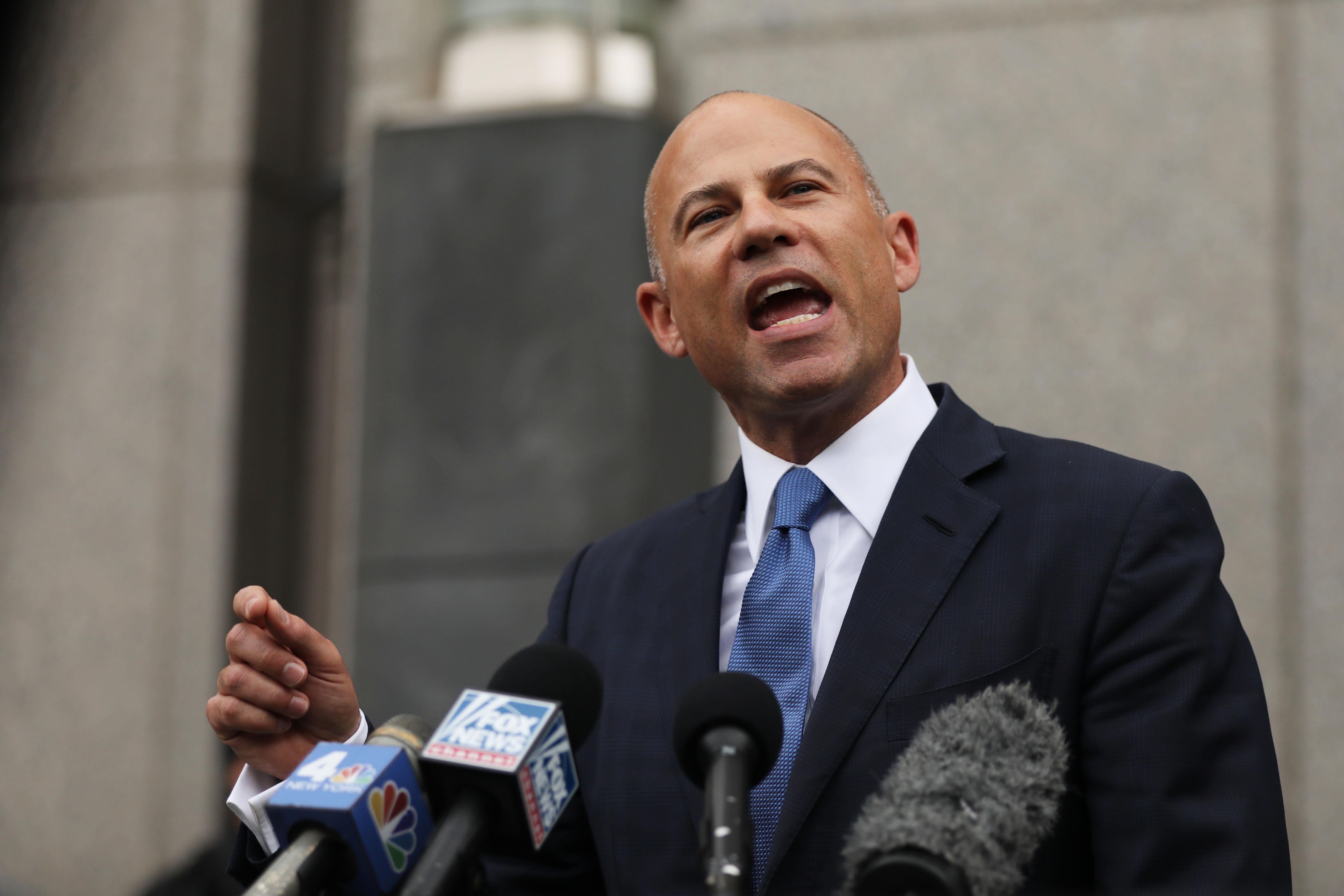 Avenatti points as he speaks into microphones outside of a New York courthouse.