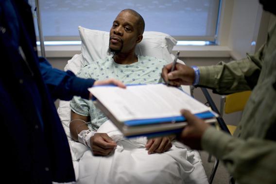 A kidney donor watches as a consent form is singed by a witness before a kidney transplant operation at Johns Hopkins Hospital June 26, 2012 in Baltimore, Maryland. 