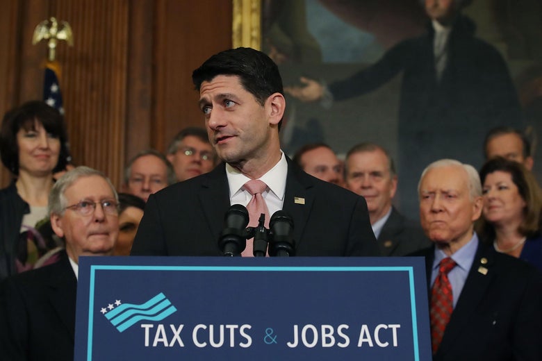 U.S. House Speaker Paul Ryan, flanked by Republican lawmakers, speaks during a ceremony for the conference report to the Tax Cuts and Jobs Act.