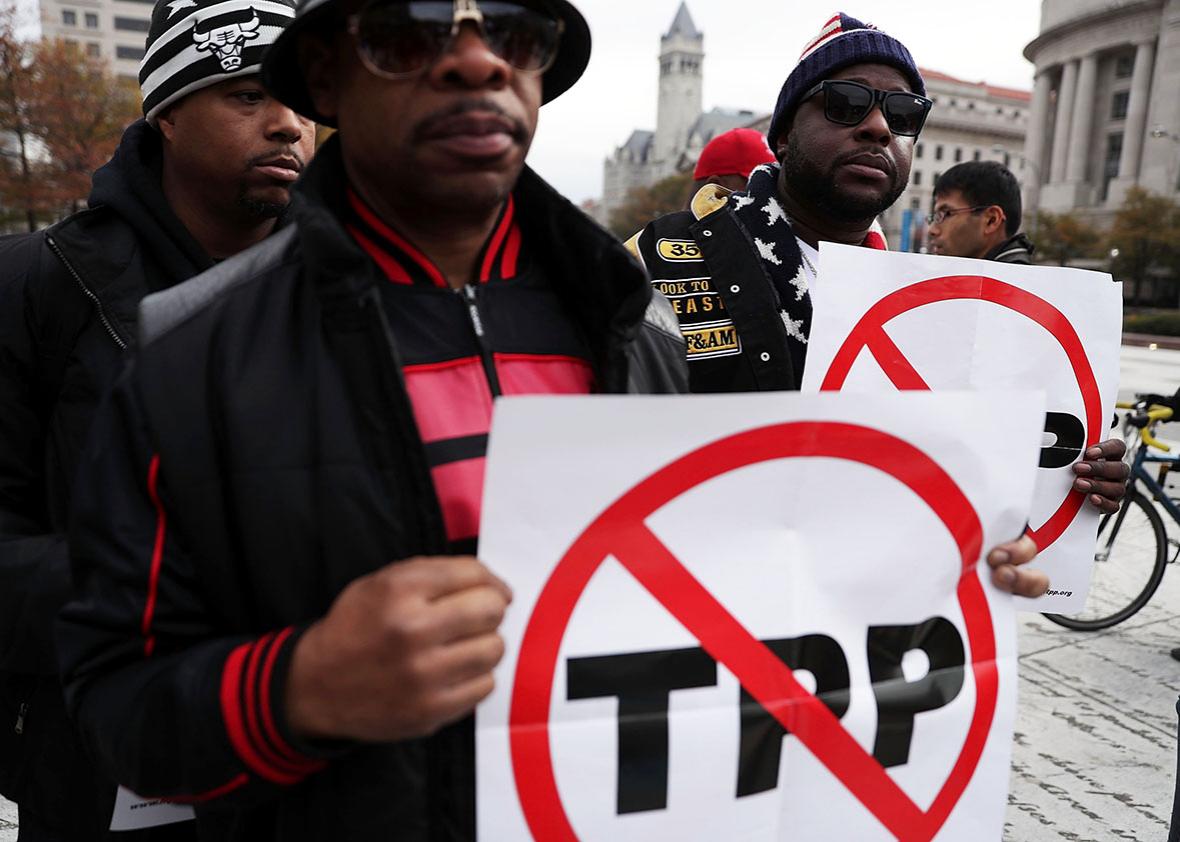 Activists hold signs as they rally during an anti-Trump and anti-TPP protest November 14, 2016 in Washington, DC. 