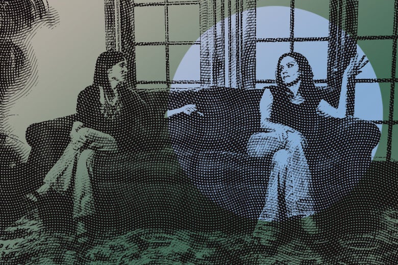 Two women sit on a couch, fighting. 