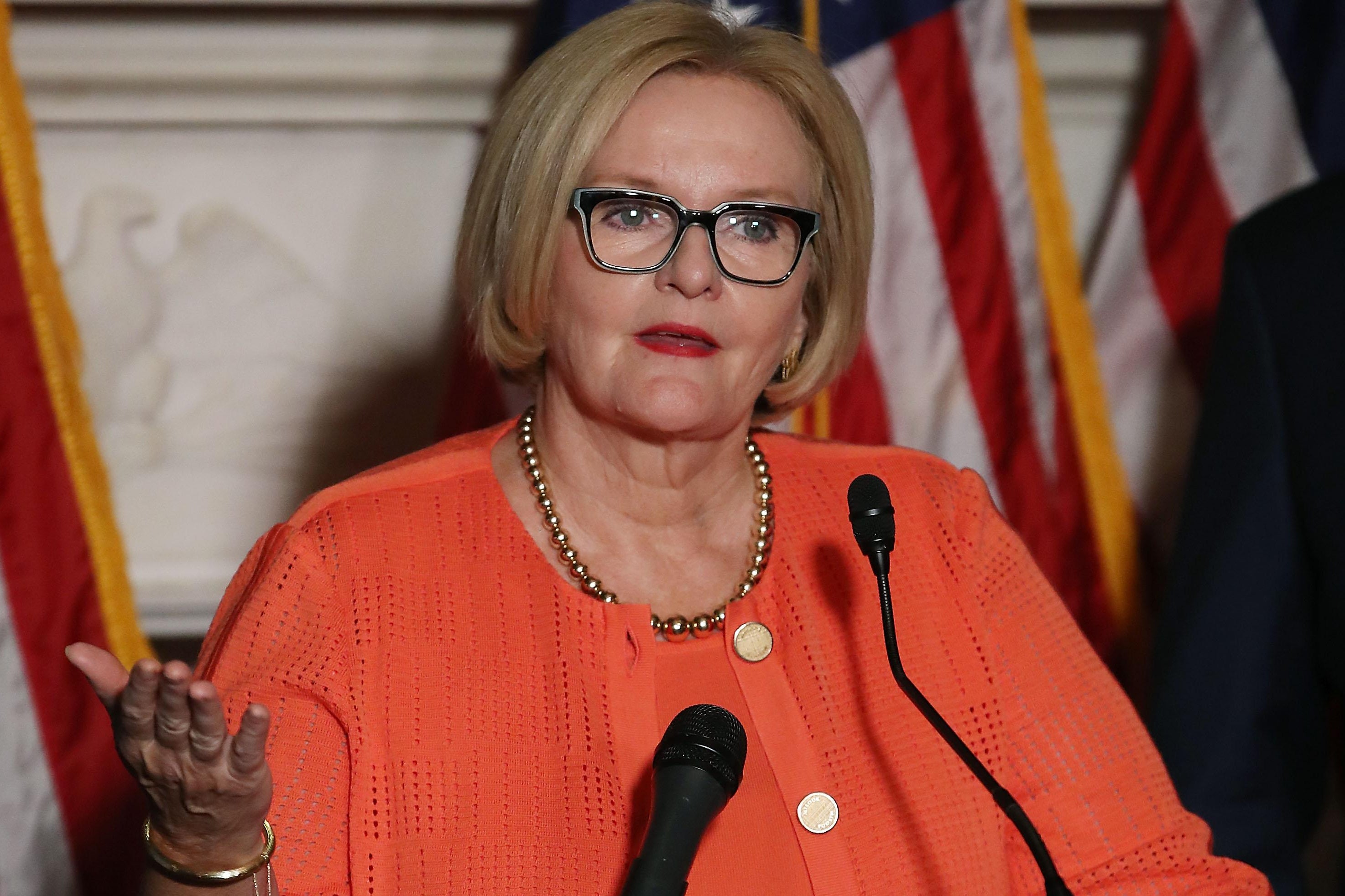 Sen. Claire McCaskill gestures with her right hand while speaking into a microphone during a news conference on Capitol Hill.