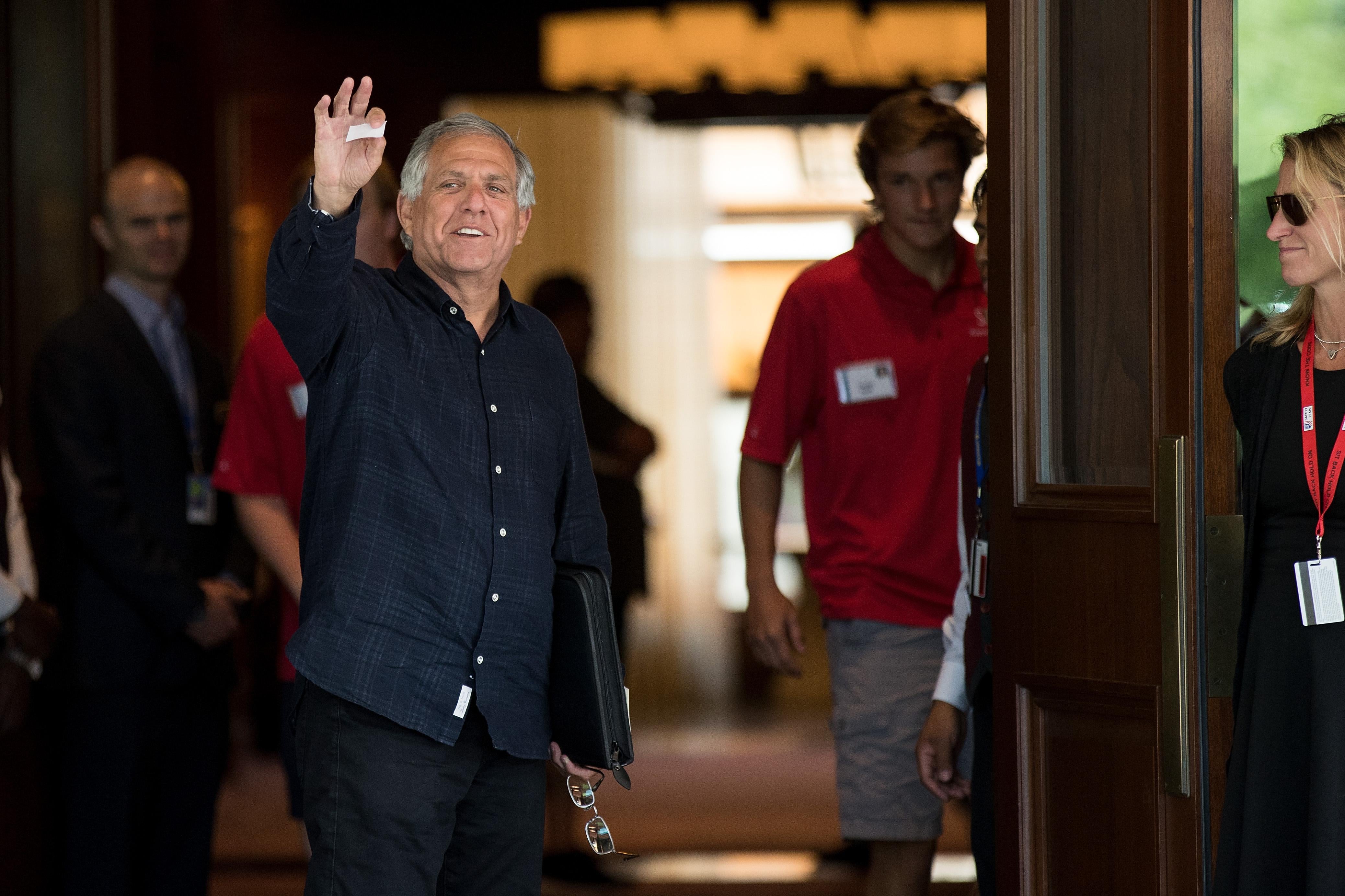 Les Moonves waves as he arrives at a conference.