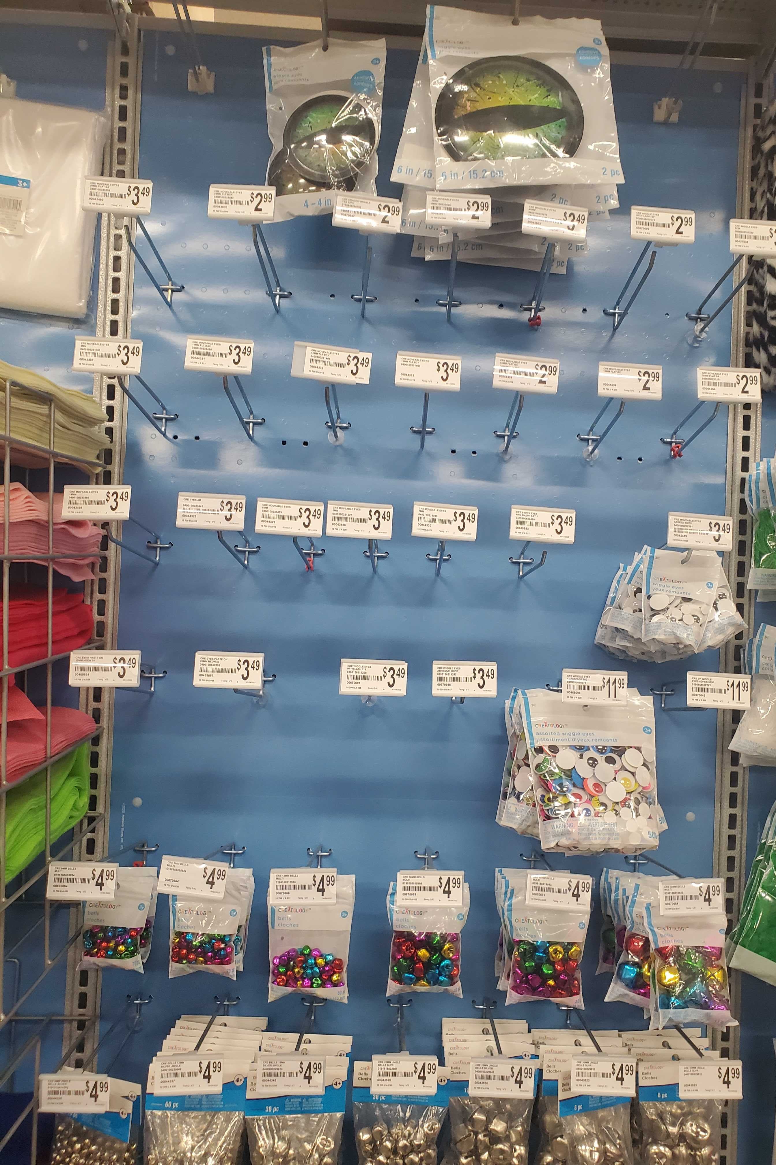 A wall of hooks for googly eyes, most of which are empty.