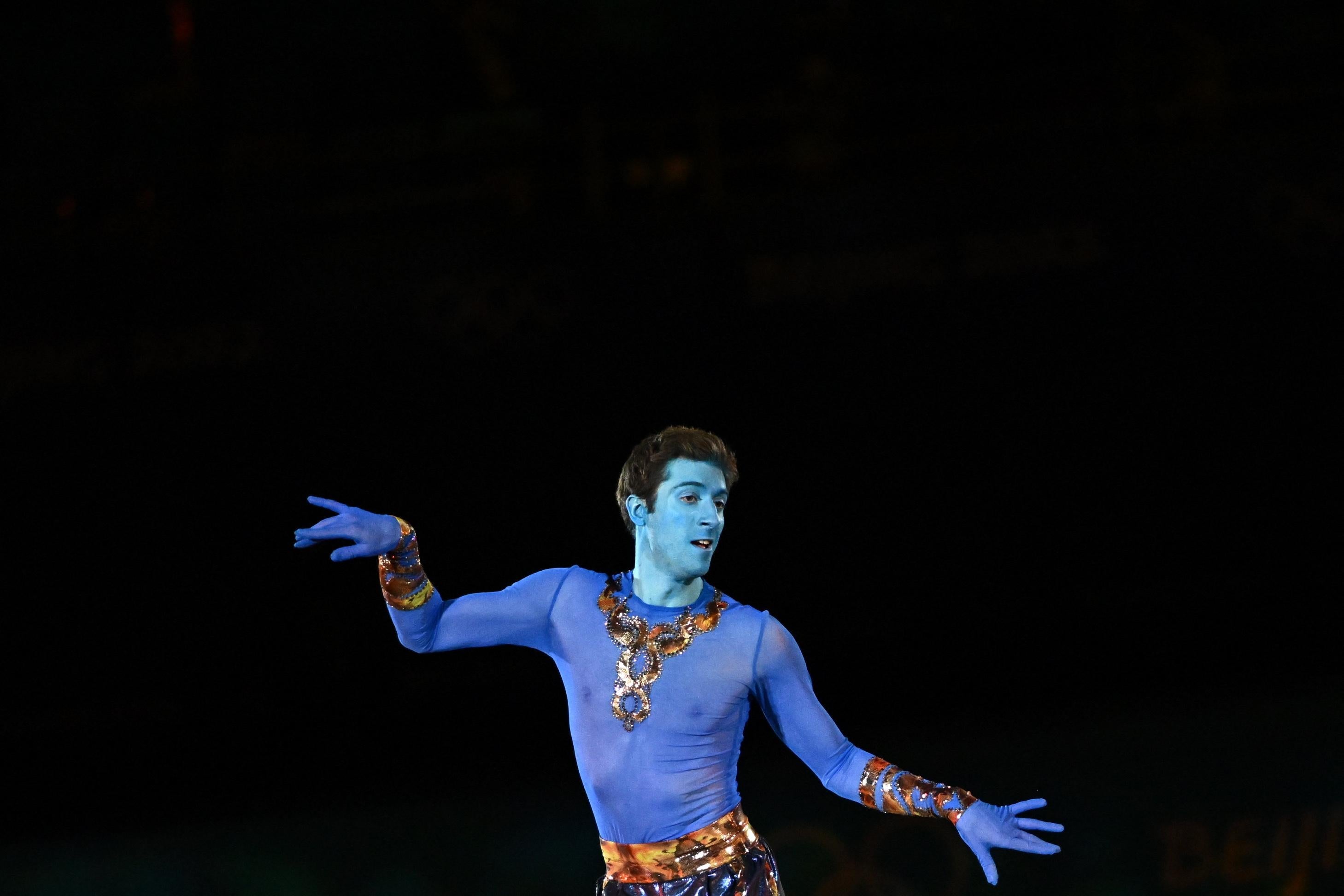 Kvitelashvili dancing with his arms out, one palm/fingers down the other palm/fingers up