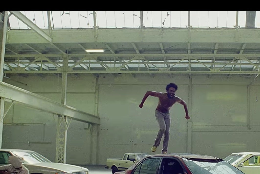 Childish Gambino (Donald Glover) stands on top of a car in the "This Is America" video.