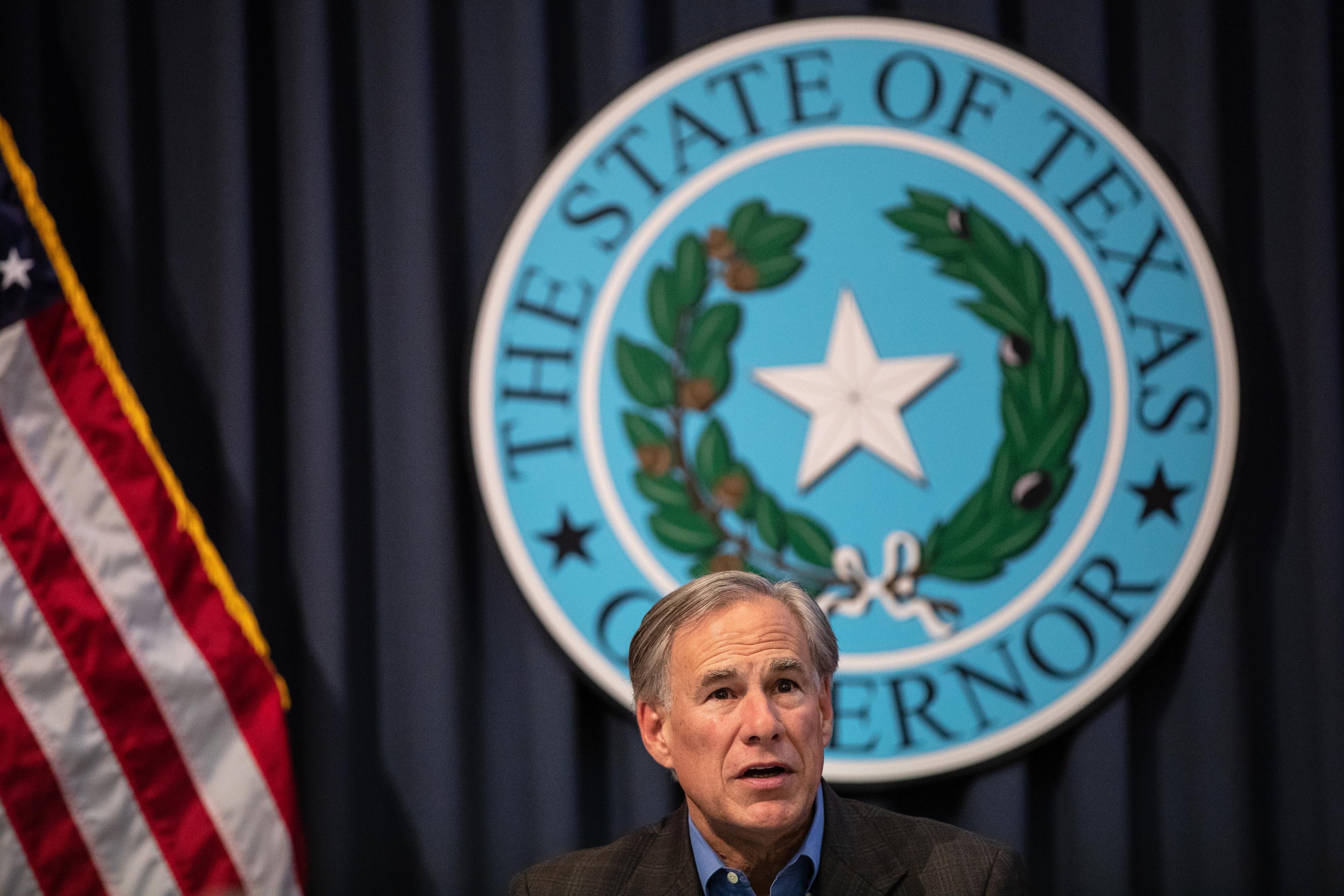 Greg Abbott speaks in front of the Texas states seal.