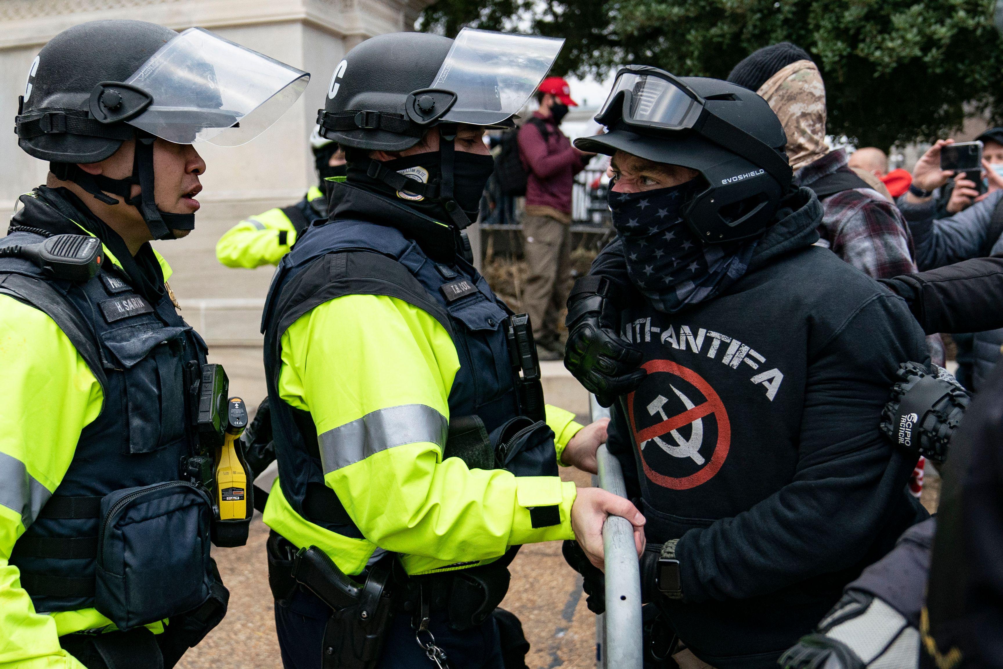 A rioter who claimed to be a member of the Proud Boys, confronts police officers outside the Capitol.