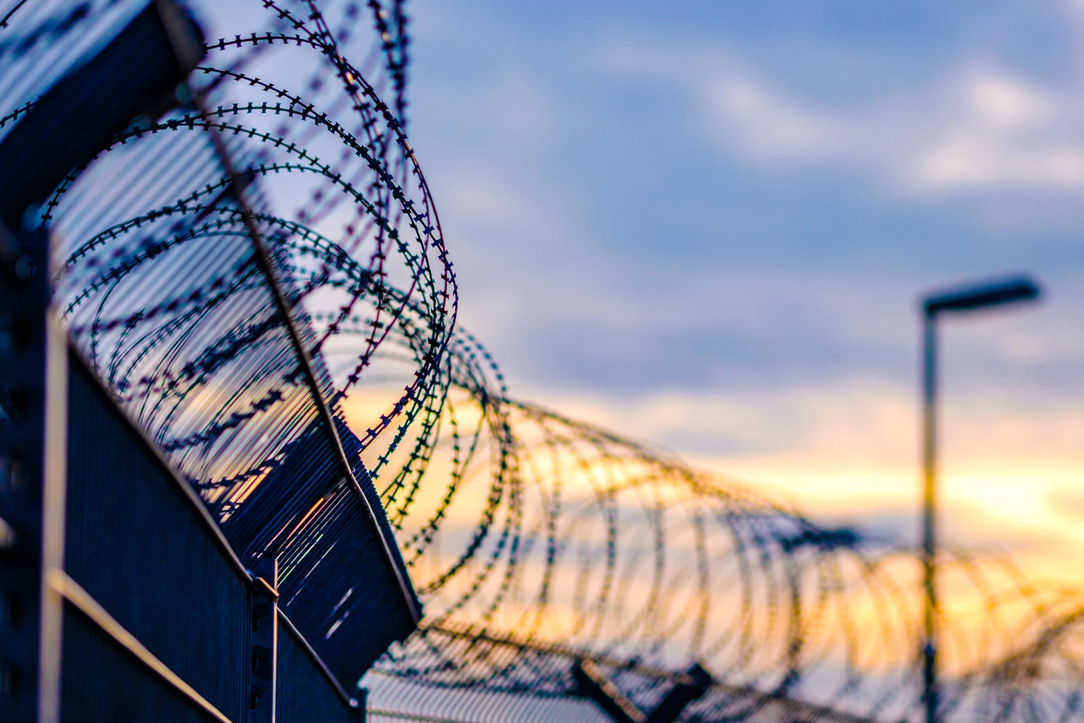 Barbed wire on the top of a fence at a correctional facility.