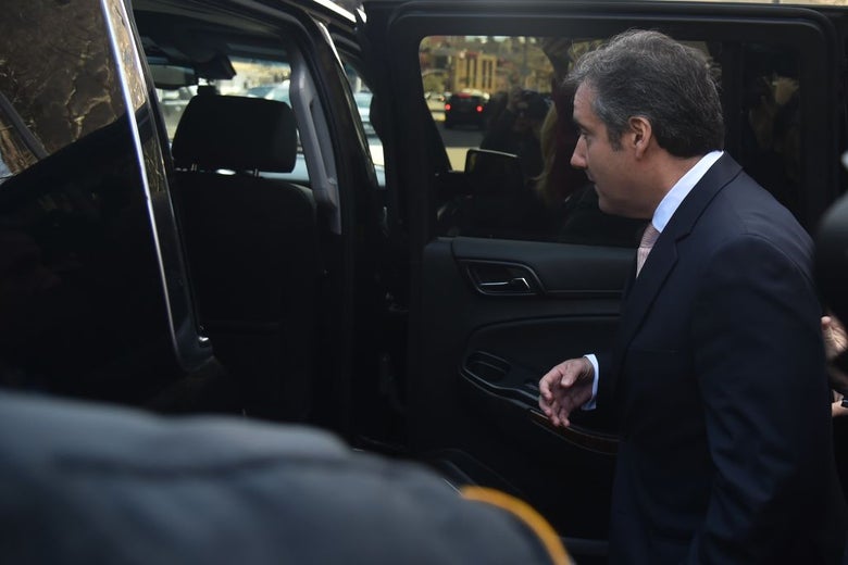 Michael Cohen prepares to enter the back seat of a black SUV.