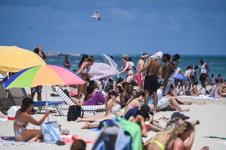 A beach crowded with people in swimsuits.