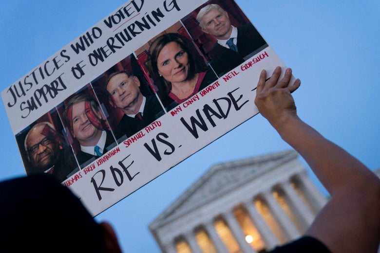 A pro-choice demonstrator holds a sign with the photos of Justices outside the US Supreme Court in Washington, DC, on May 3, 2022. 