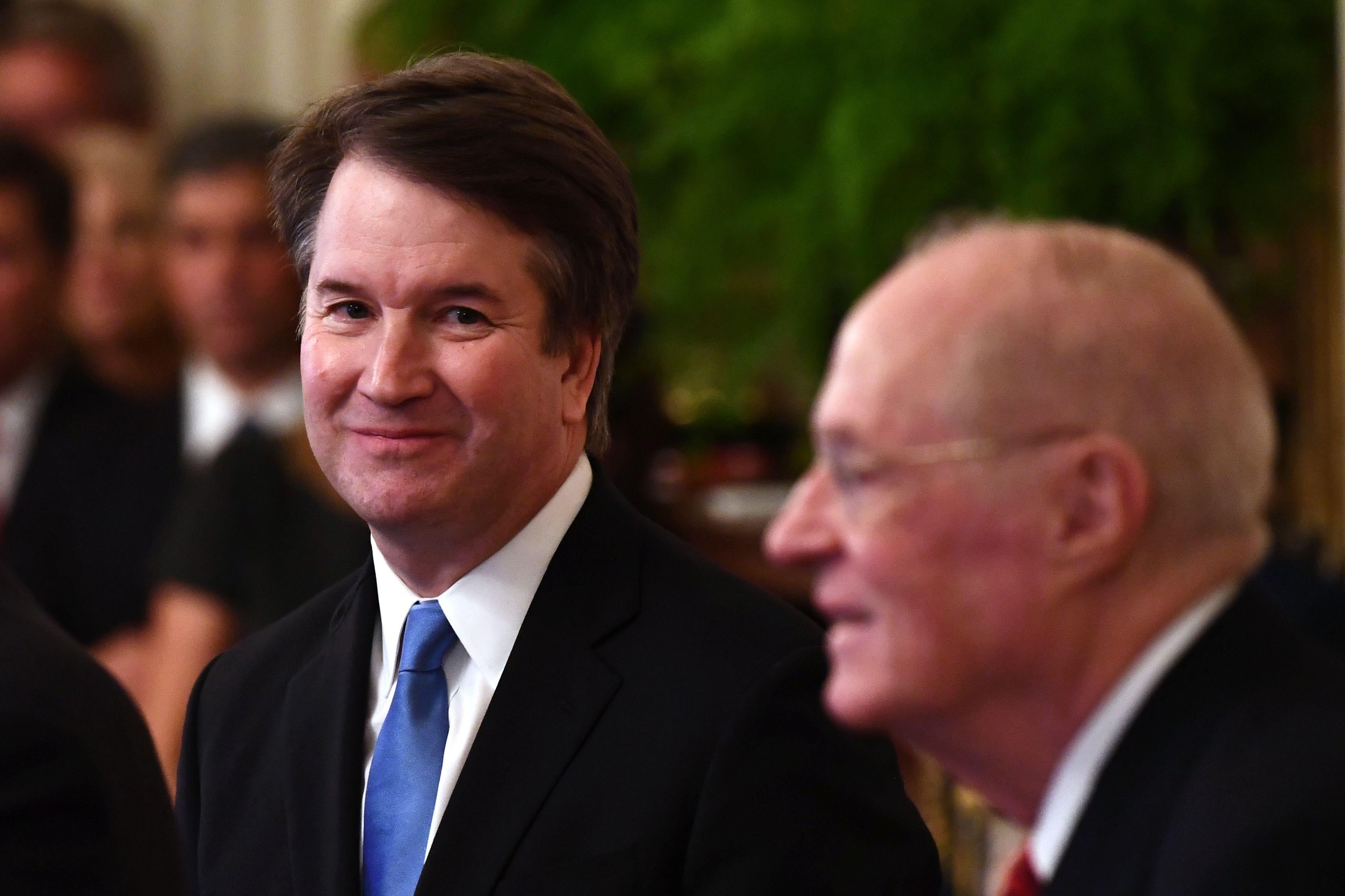 Kavanaugh with a wide grin as Kennedy is a bit blurry.