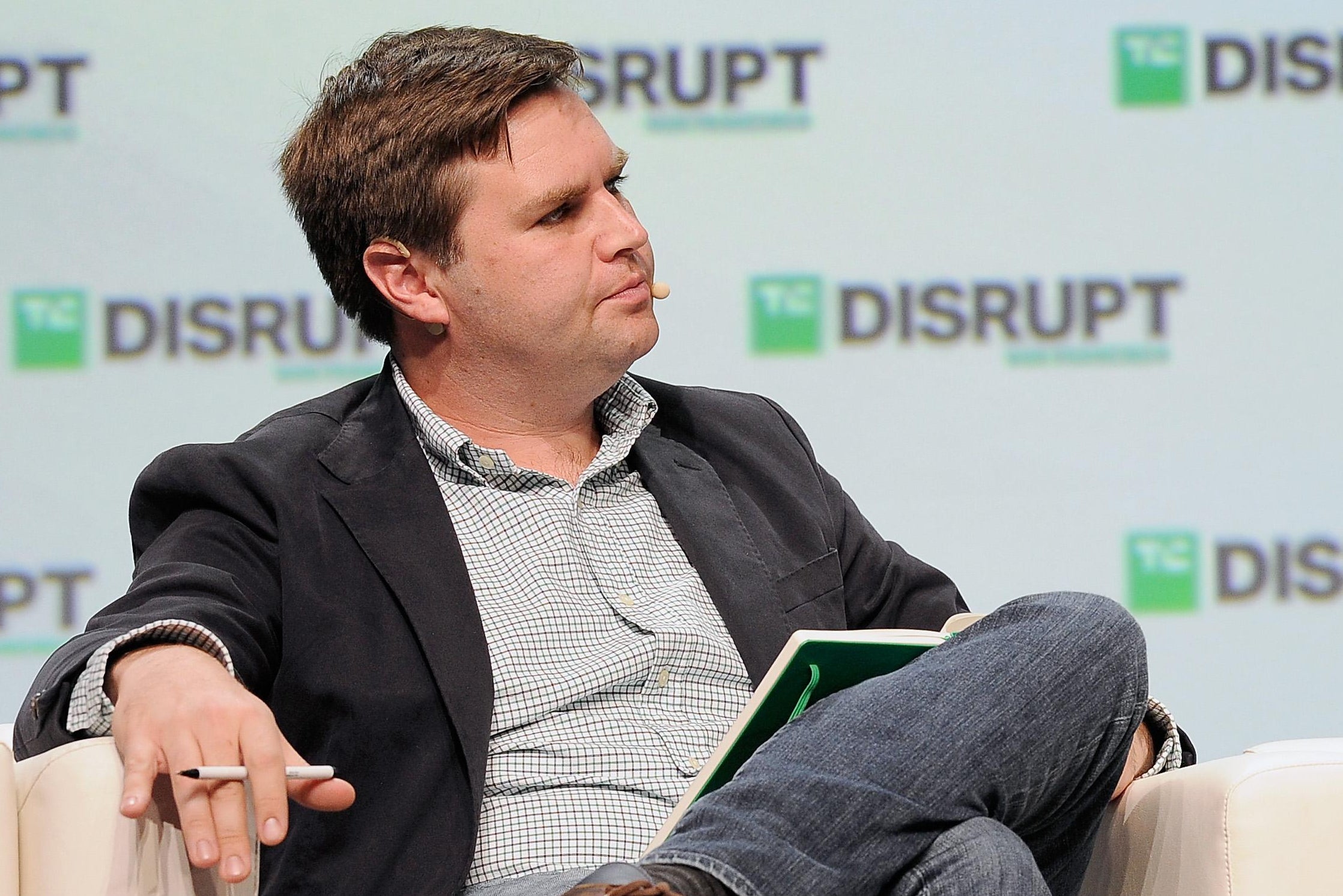 J.D. Vance sits in a white easy chair onstage at a tech event.