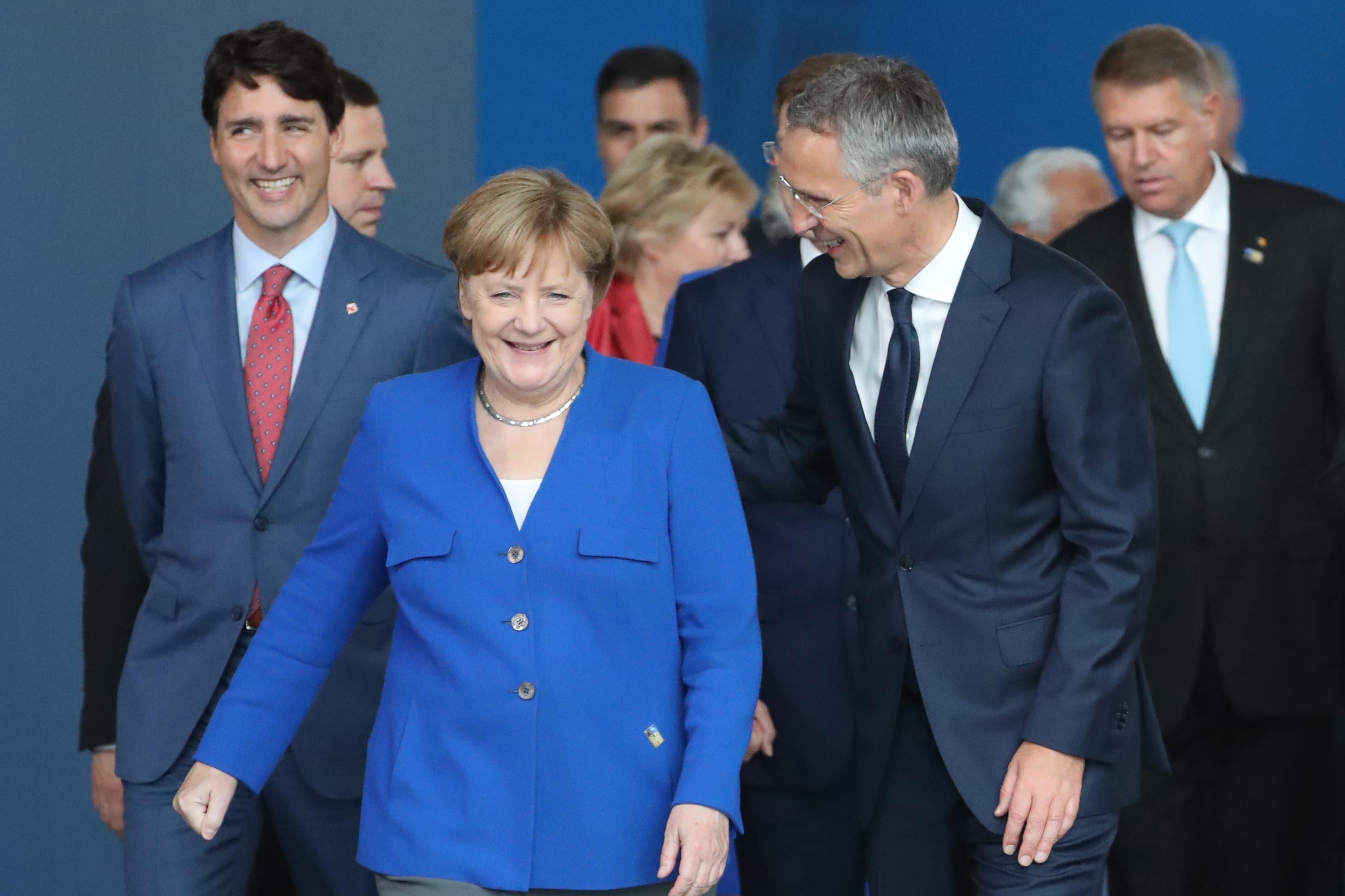 Angela Merkel and other world leaders walk toward the camera.