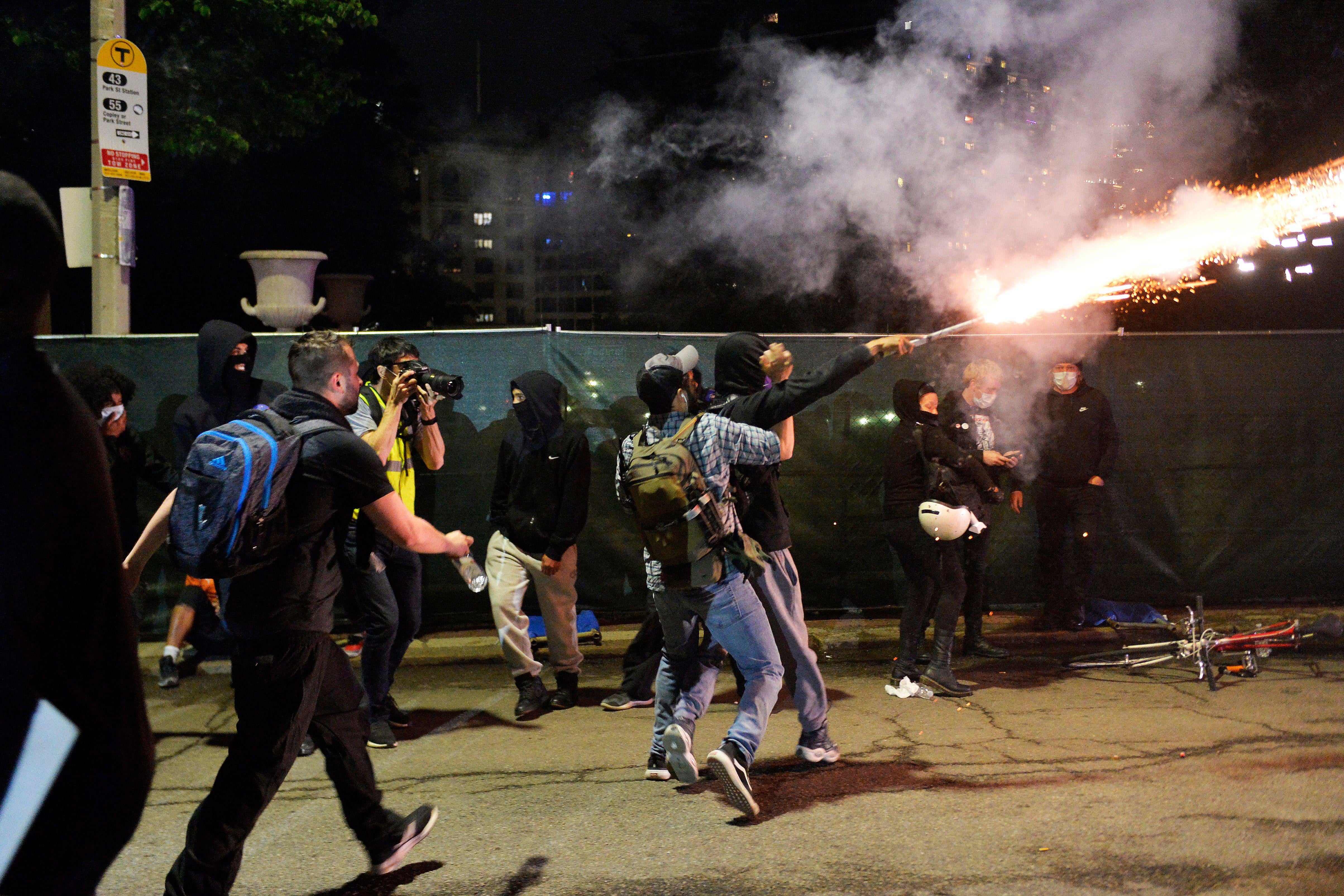 Protesters tackle a man setting off fireworks.