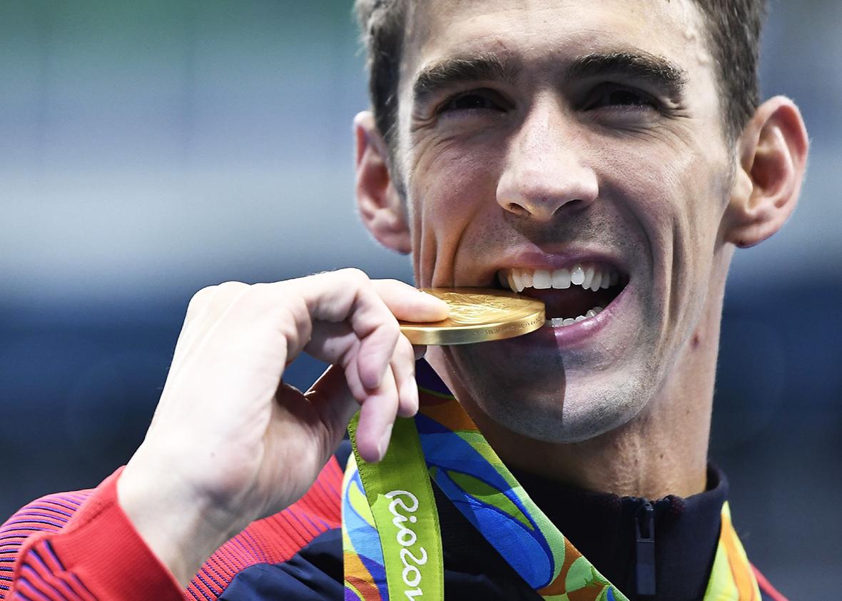 USA's Michael Phelps kisses his gold medal on the podium after Team USA won the Men's 4x200m Freestyle Relay Final during the swimming event at the Rio 2016 Olympic Games at the Olympic Aquatics Stadium in Rio de Janeiro on August 9, 2016.   