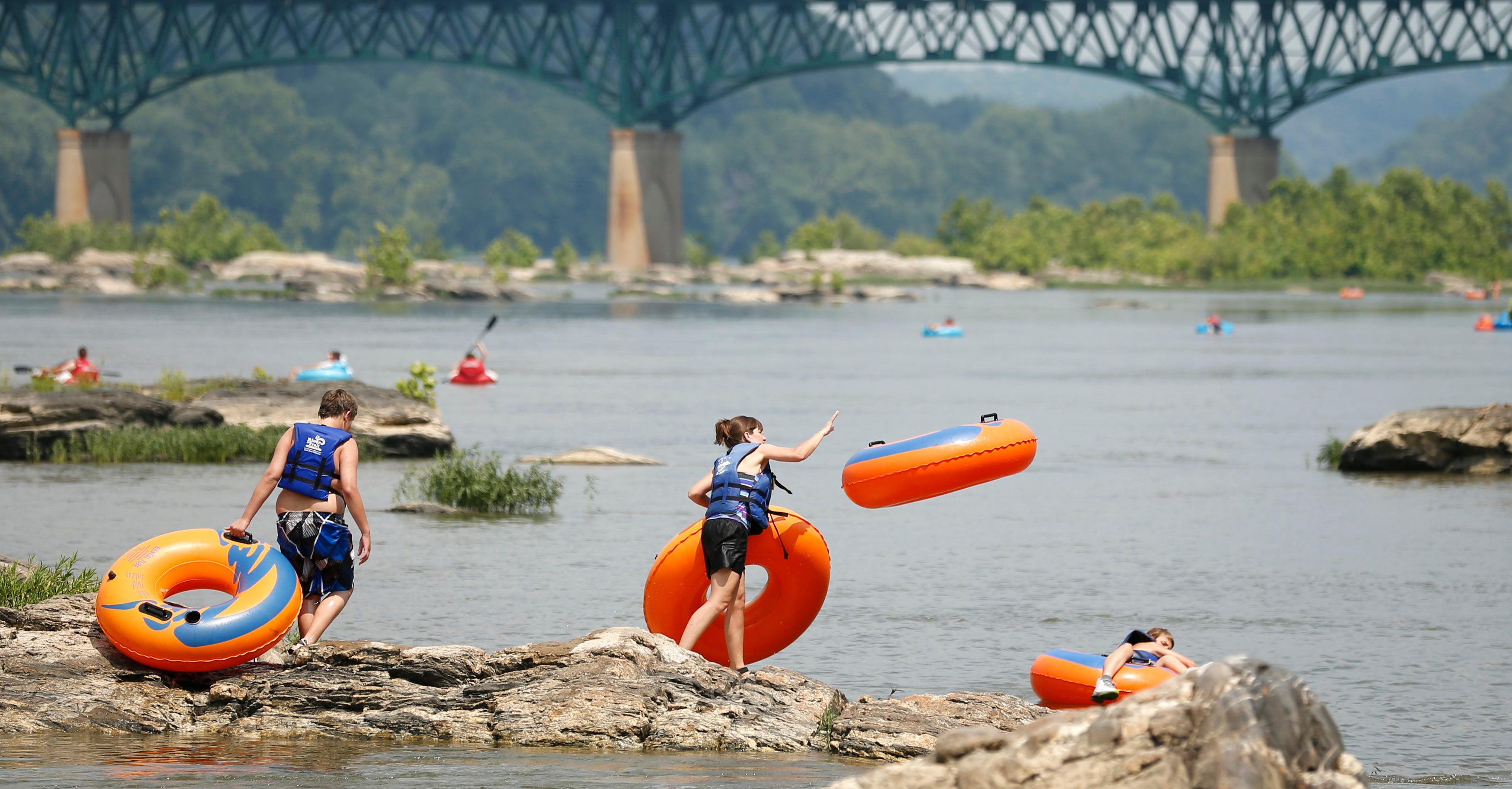 A woman hurls an inner tube into the Potomac River in Harpers Ferry, Virginia.