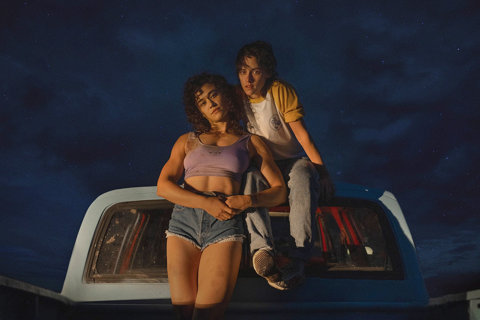 The two actresses sit in a truckbed, leaning against the cabin, against a backdrop of the night sky. O’Brian is ripped in Daisy Dukes and what looks like a sports bra. Stewart wears a raglan tee and jeans and smolders at the camera.