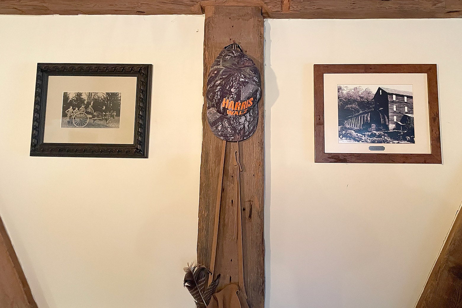 A Harris/Walz camo hat hanging on a wall.