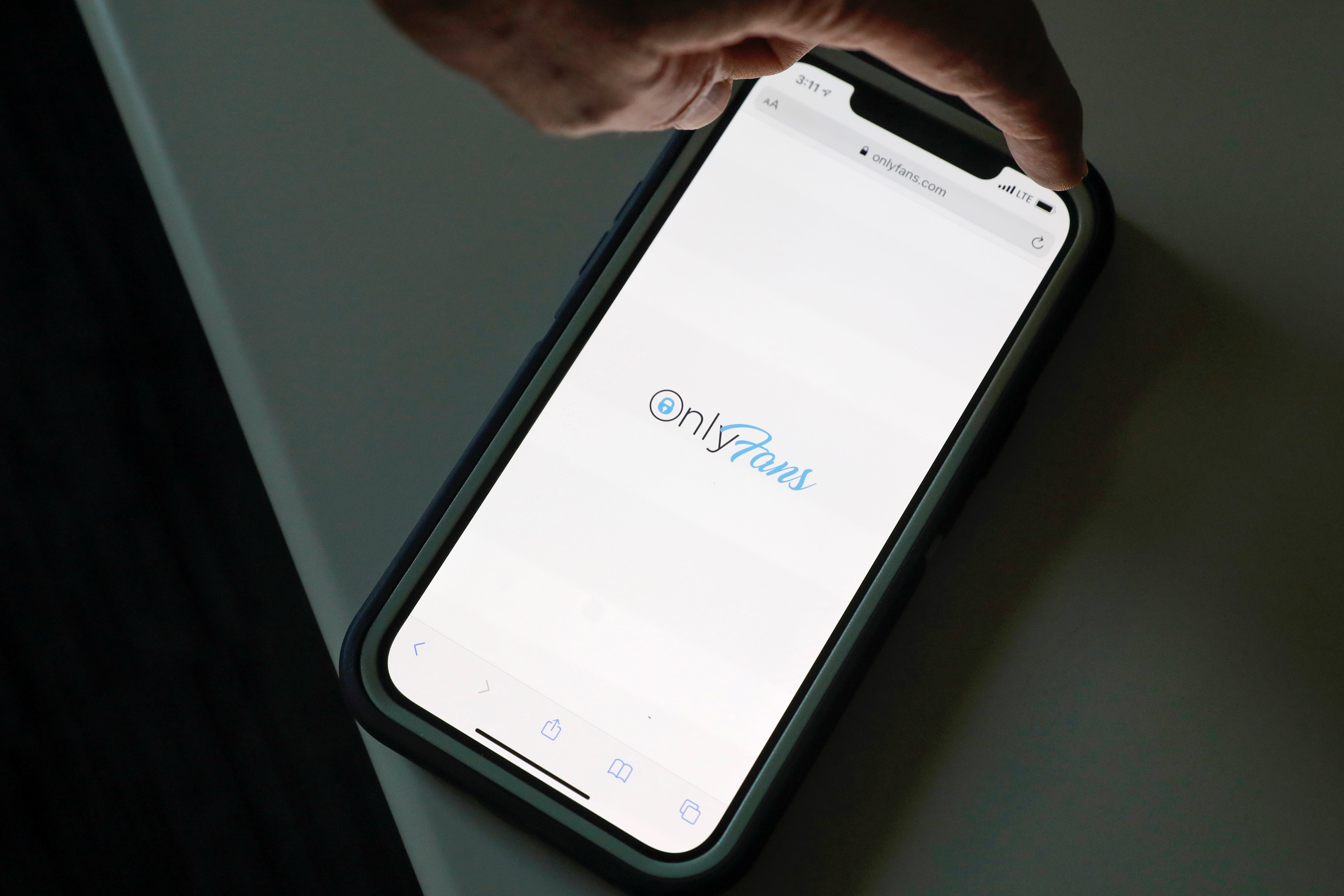 A smartphone with a browser showing the OnlyFans logo.