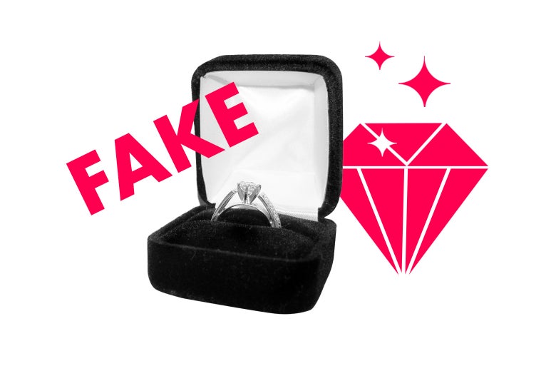 An engagement ring in its box with the word FAKE over it.