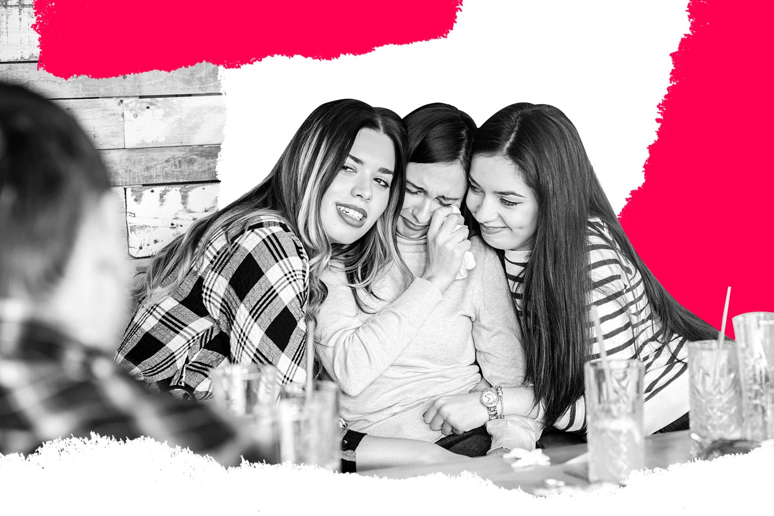 Two women console a third woman who is crying.