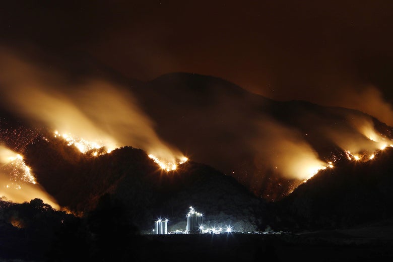 Smoke from the Holy Fire burning in Cleveland National Forest is blurred in a long exposure above an industrial storage facility on August 10, 2018 in Corona, California.