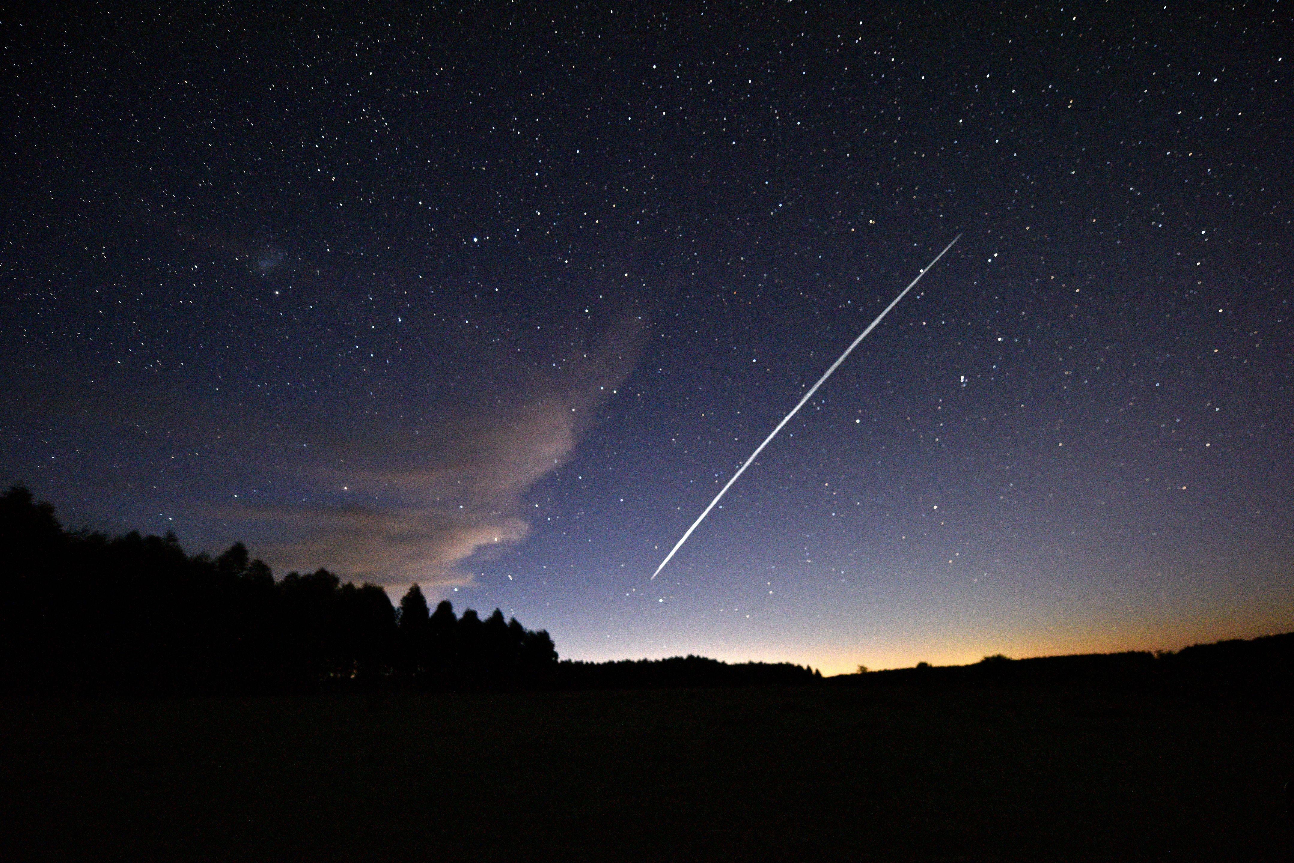 A long-exposure image of a Starlink satellite crossing the night sky, a bright line across a background of stars.