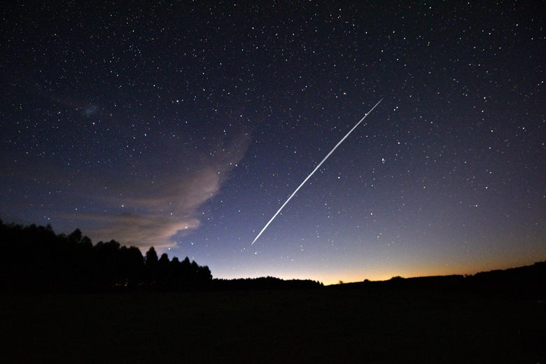 A long-exposure image of a Starlink satellite crossing the night sky, a bright line across a background of stars.
