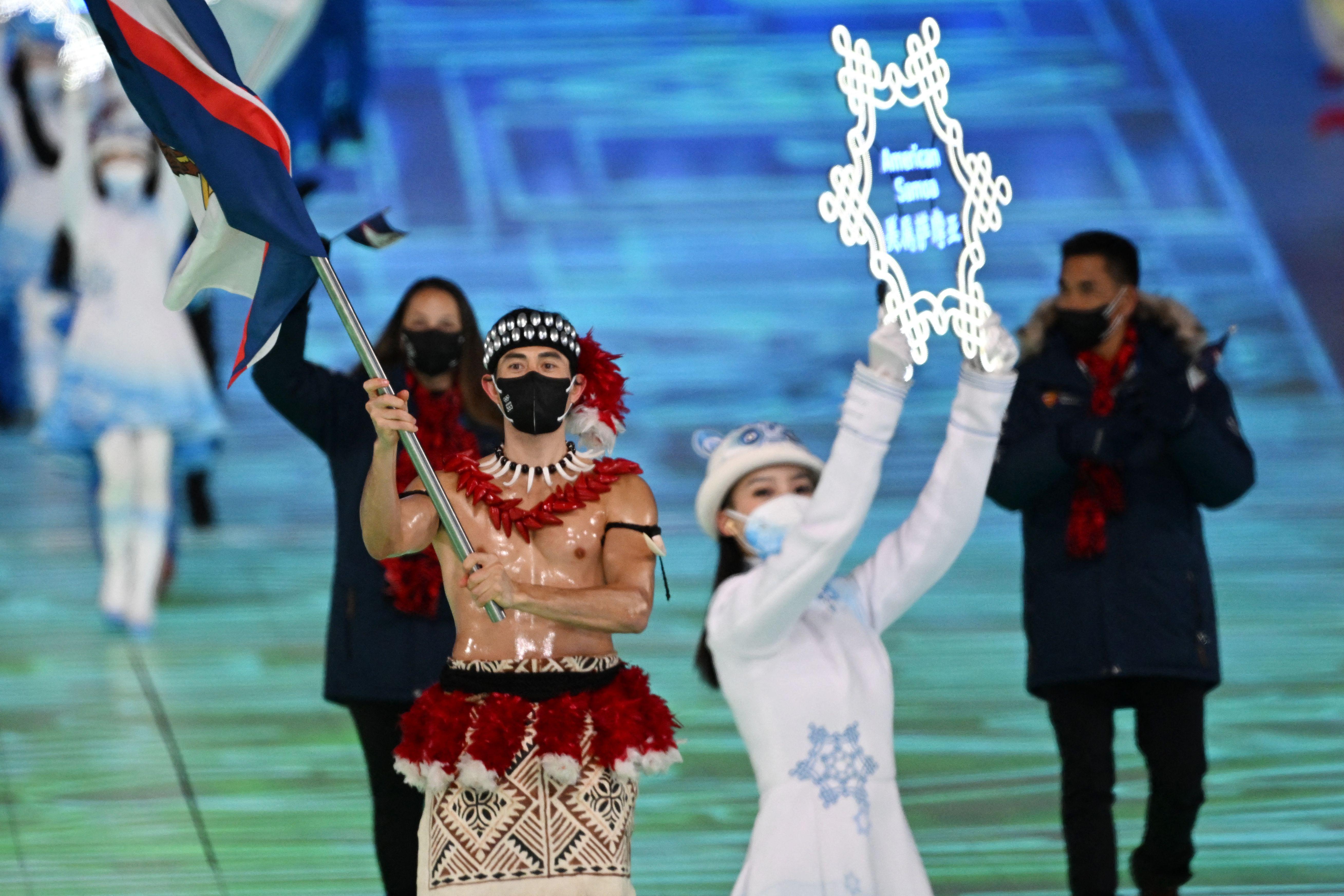 American Samoa's flag bearer Nathan Crumpton walks topless.