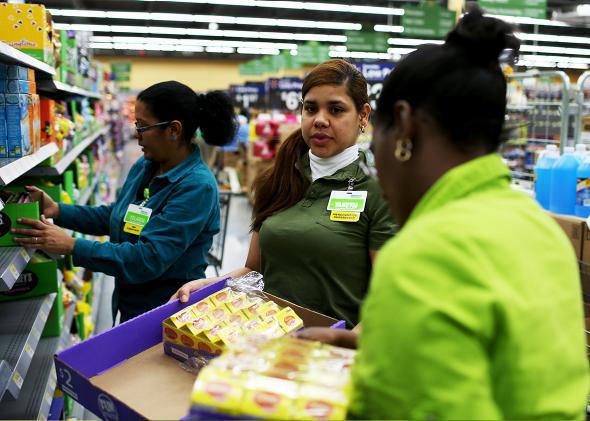 Walmart employee Yanetsi Grave and her fellow employees stock the shelves at a Walmart store on February 19, 2015 in Miami, Florida. 