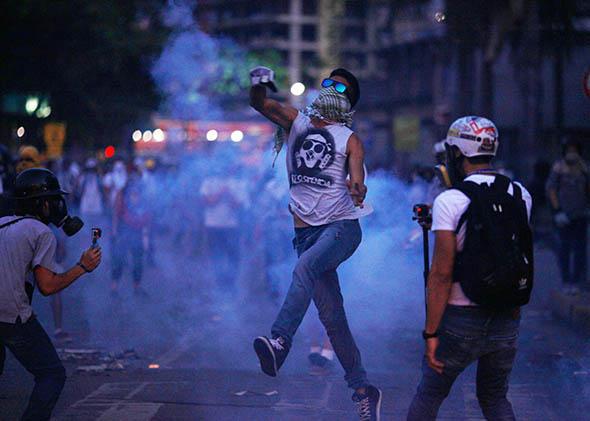 Opposition demonstrators are attacked with tear gas by riot police during a protest in Caracas on April 4, 2014. 