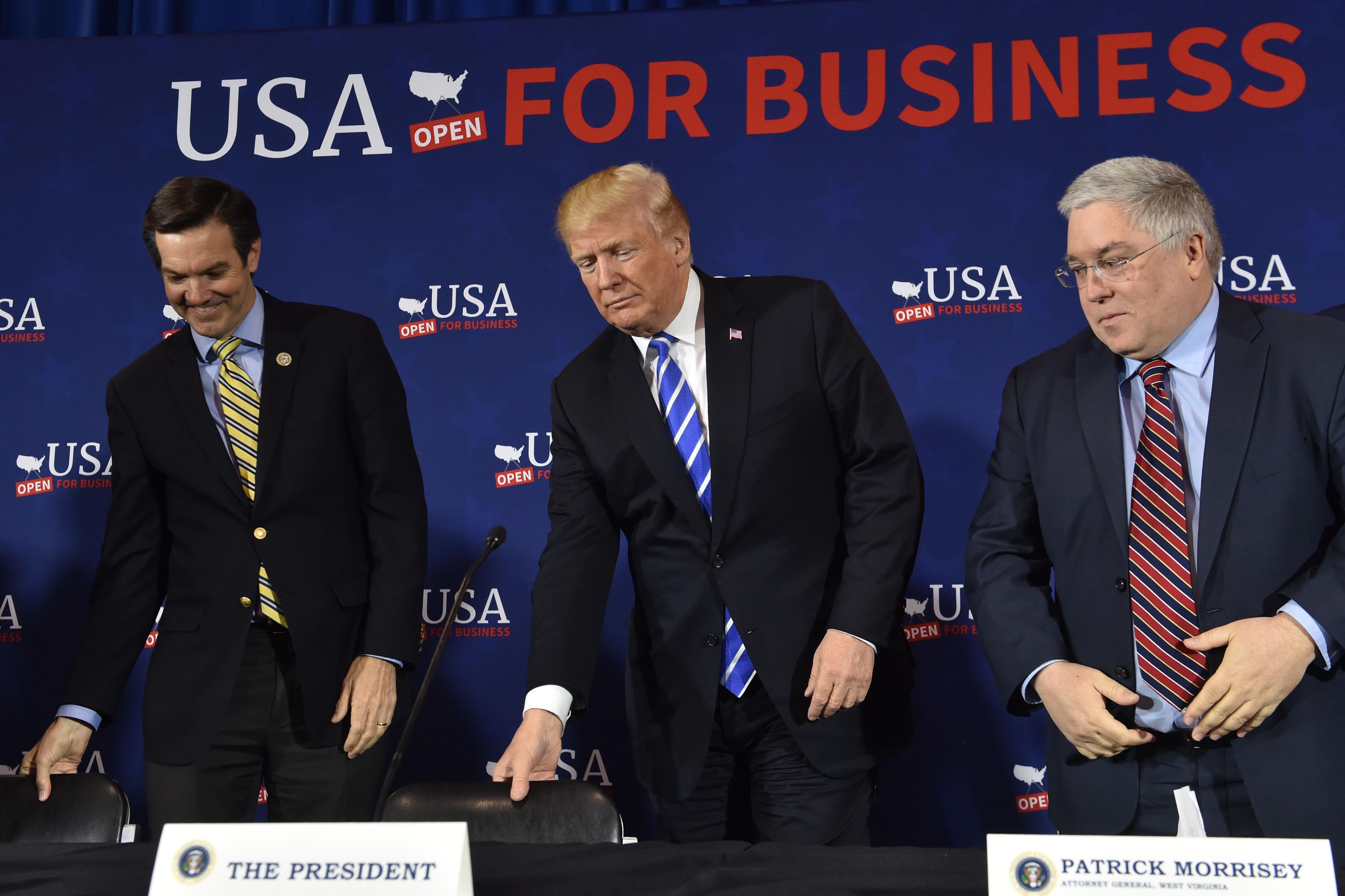US President Donald Trump(C) arrives for a round table discussion on tax reform, at White Sulpher Springs Civic Center in White Sulpher Springs,West Virginia on April 5, 2018. 
Shown to his left is Rep. Evan Jenkins, and (R)West Virginia Attorney General Patrick Morrissey.   / AFP PHOTO / Nicholas Kamm        (Photo credit should read NICHOLAS KAMM/AFP/Getty Images)
