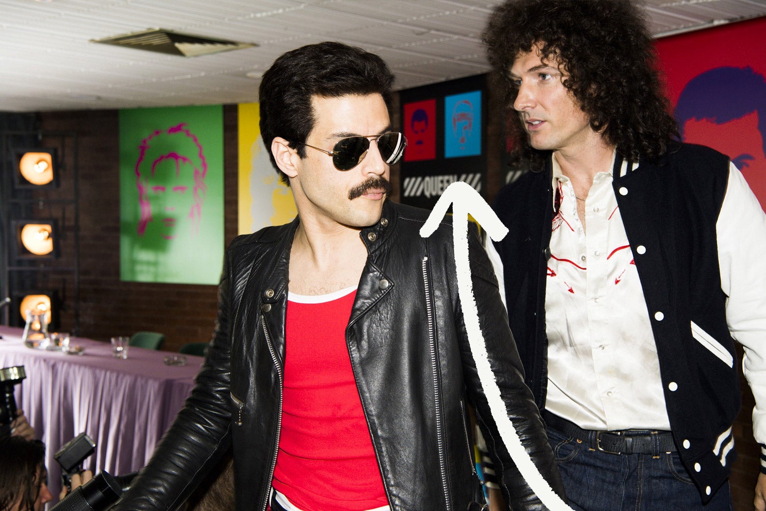 Scene from Bohemian Rhapsody with Hot Space album art in background
