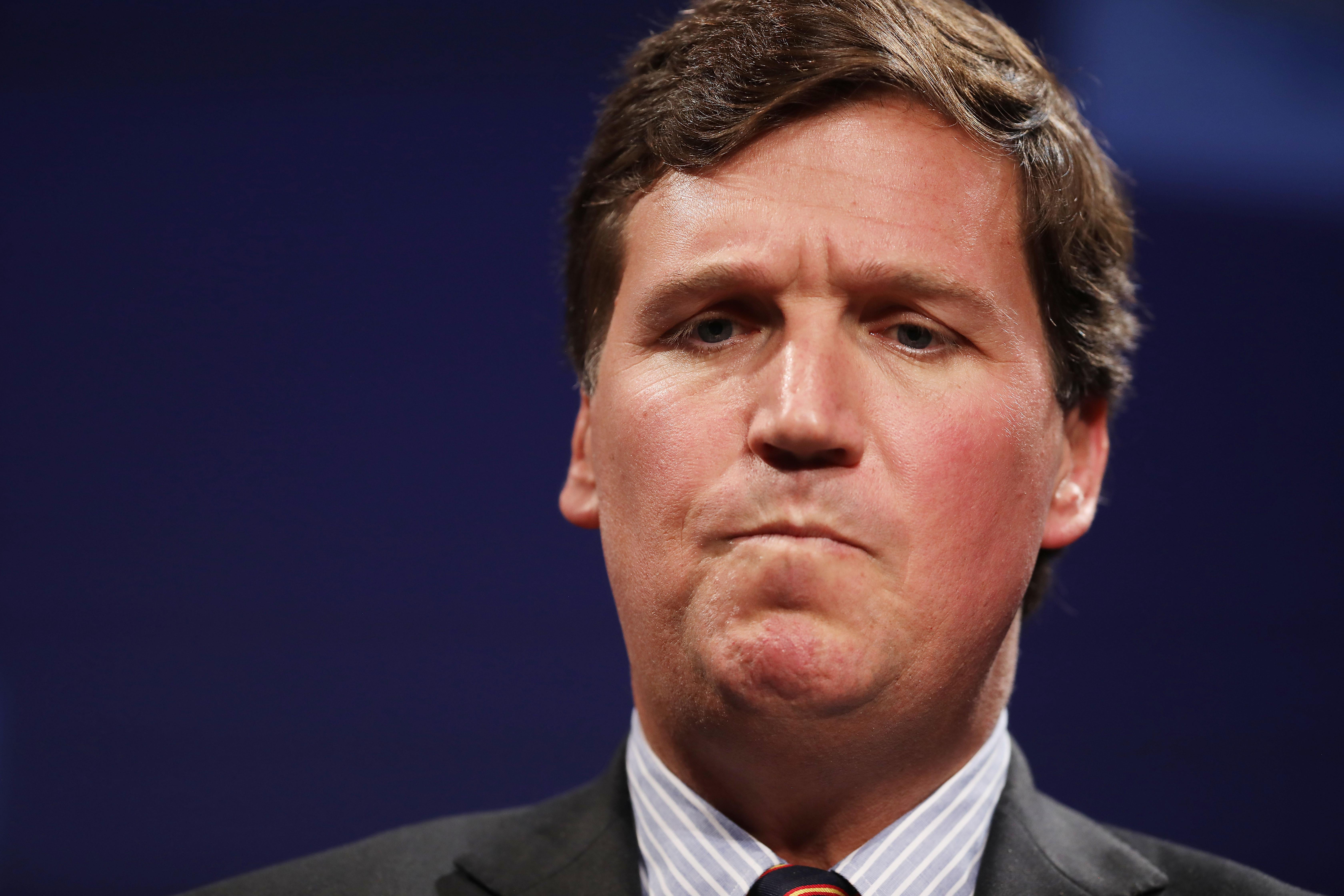 A close-up of Tucker Carlson's face frowning.