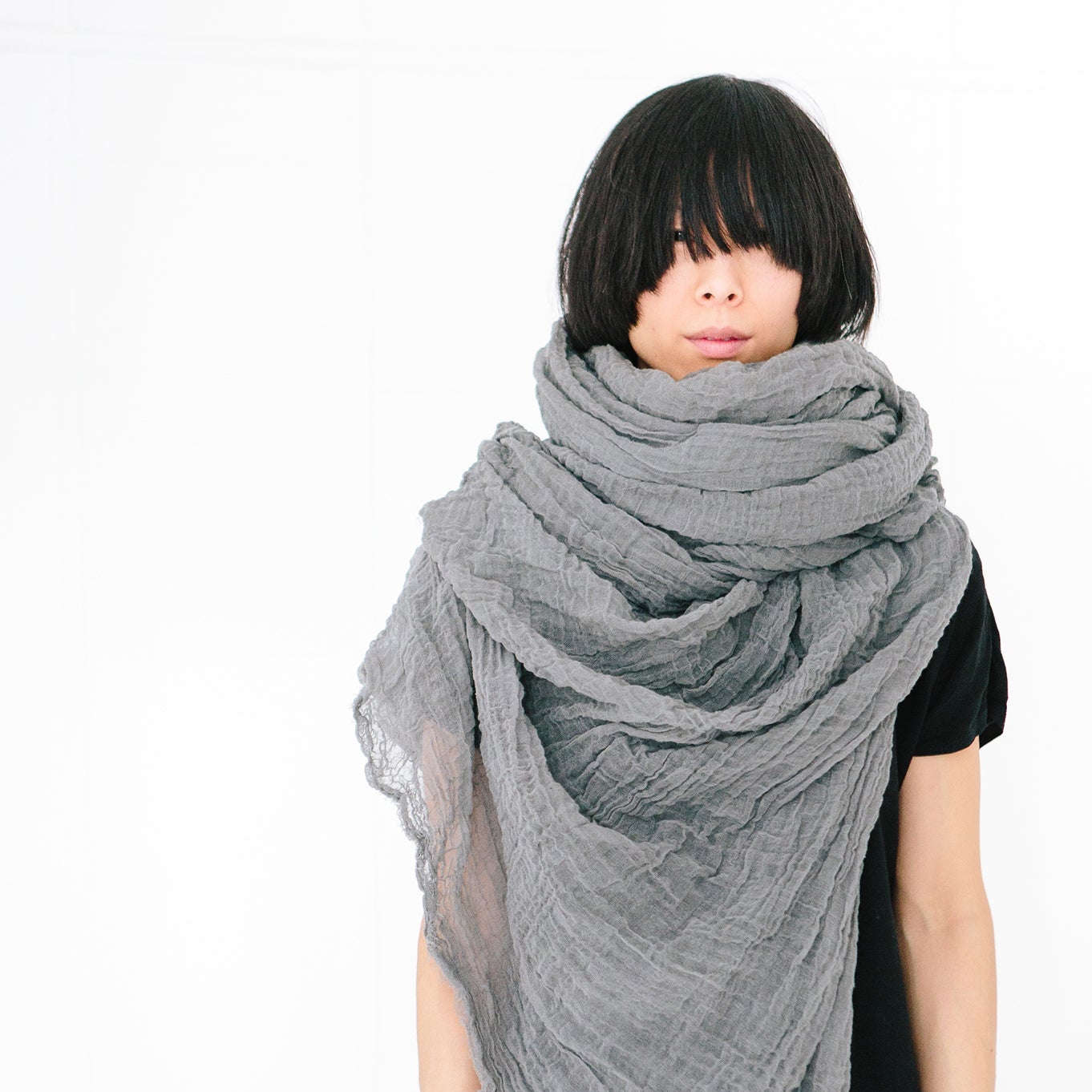 A woman wearing a Scarf Shop cotton giant scarf