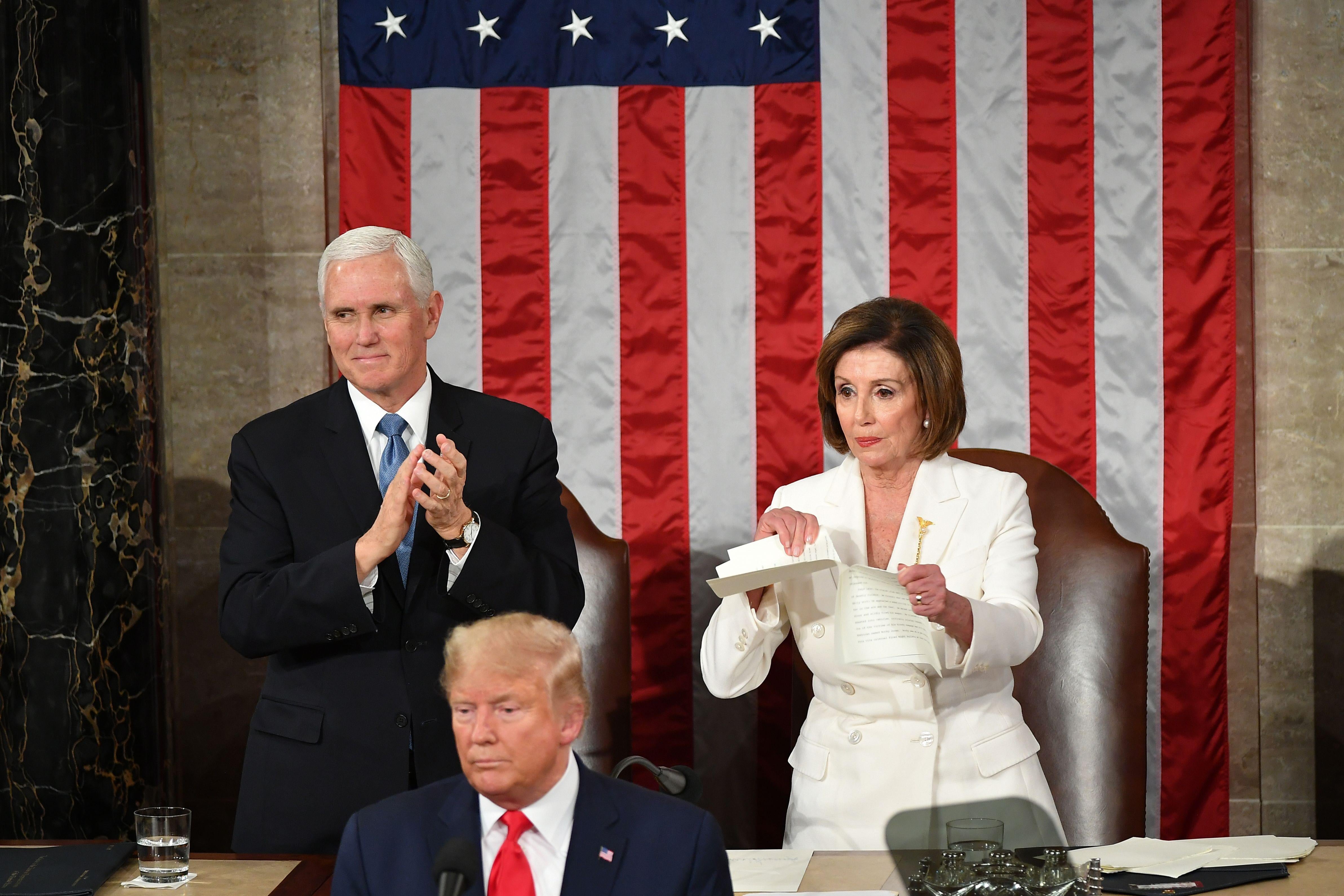 Vice President Mike Pence claps as House Speaker Nancy Pelosi rips a copy of President Donald Trump's State of the Union in Washington, DC.
