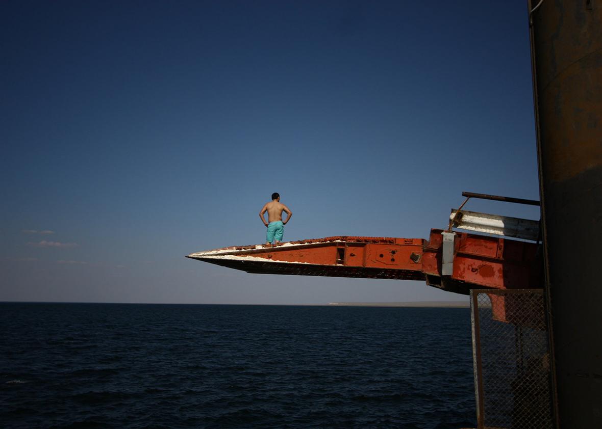 Sarytas. Preparing to dive off a pier into the Caspian Sea, next to the spot where Russian geographers have determined is the true border between Europe and Asia.