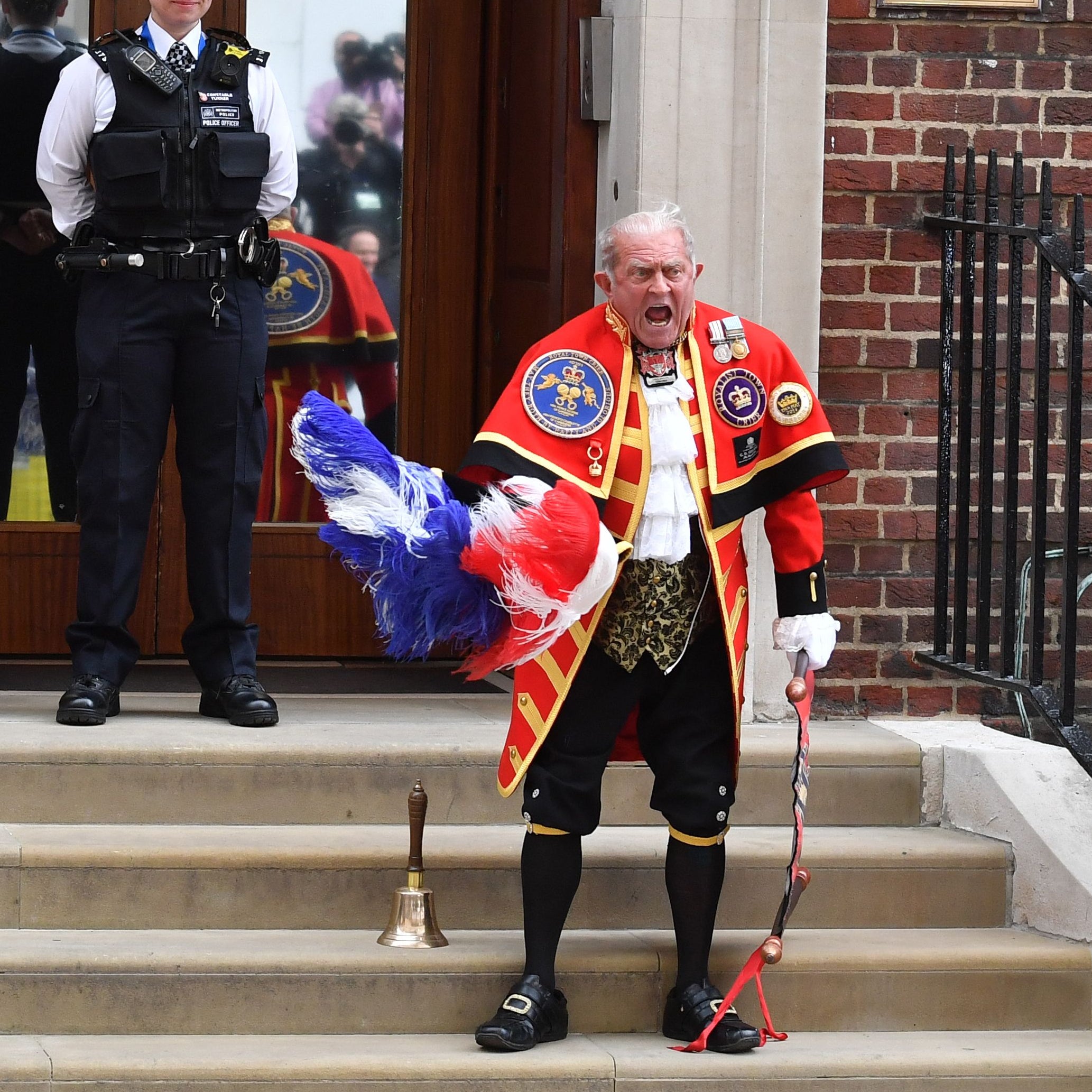 A town crier reads the news of the royal birth.