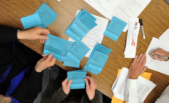 Volunteers count ballots from voters during a Republican caucus.
