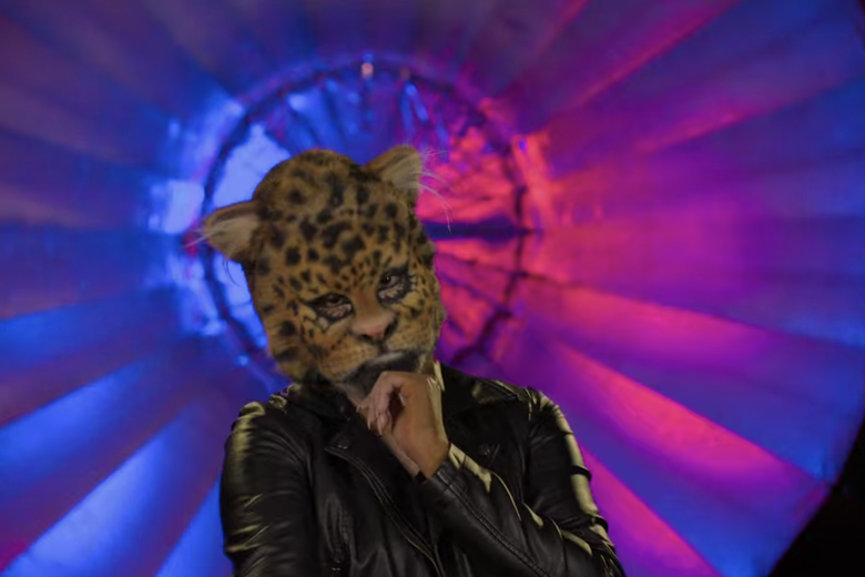 A woman in a brown jacket with a leopard head.